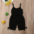 Black romper on a wooden surface with decorative elements.