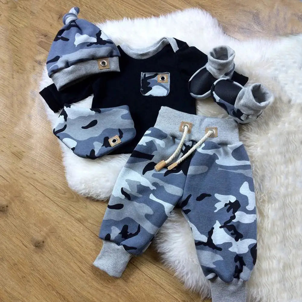 Baby outfit set with camouflage pattern on a wooden floor