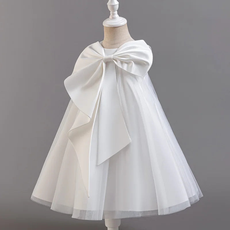 White tulle dress with a large bow on a mannequin against a gray background