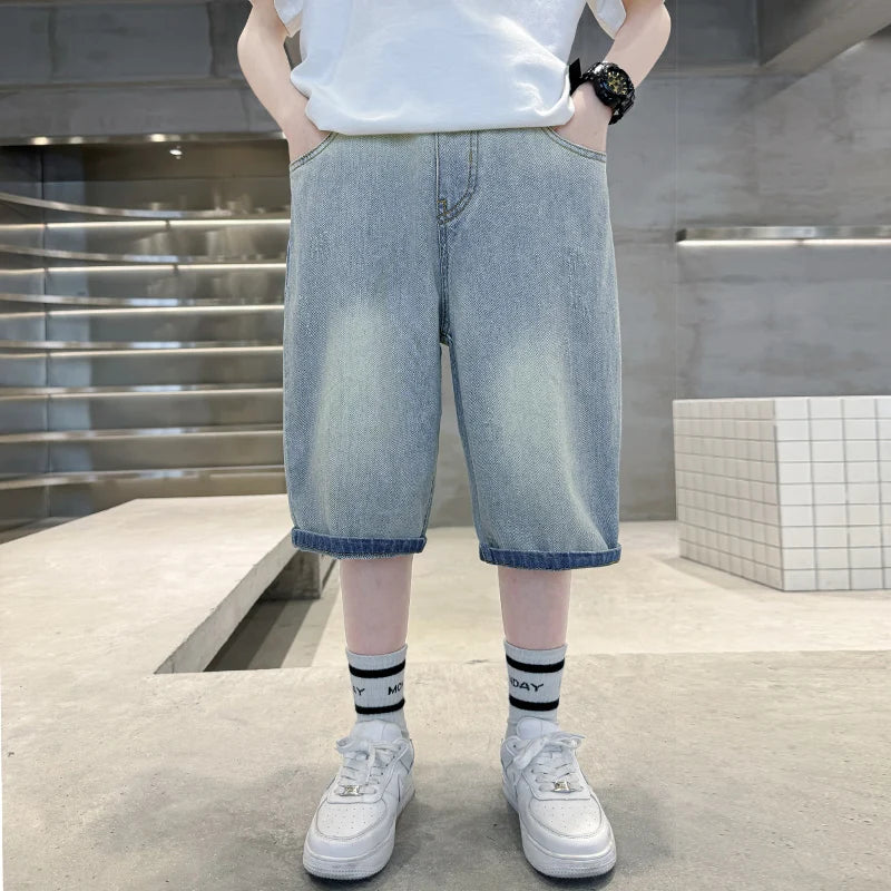 Person wearing light blue denim shorts and white sneakers in an indoor setting.