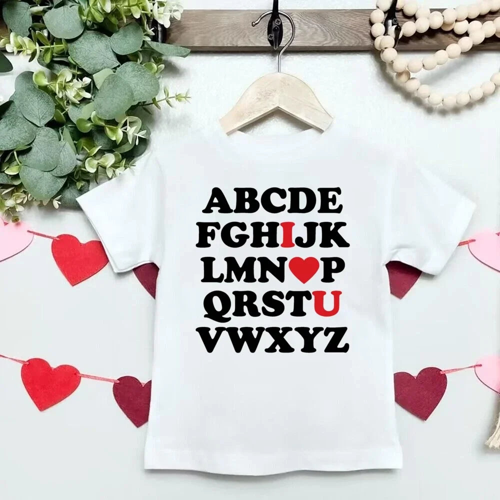 White t-shirt with black and red text on a hanger with decorative elements.