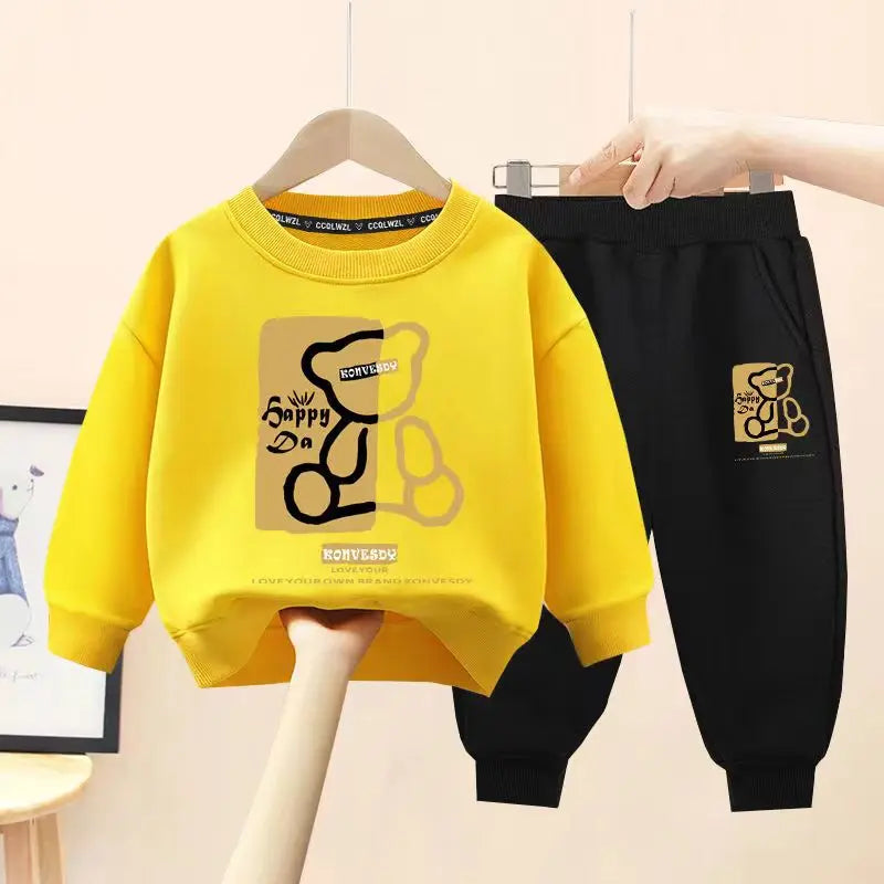 Yellow sweatshirt and black pants with a logo on hangers against a light background