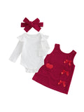 Baby outfit set with white onesie, red dress with heart and bow details, and matching headband on a white background.