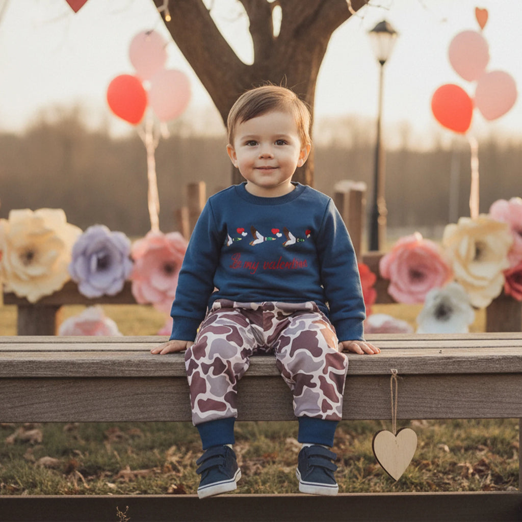 Child sitting on a bench with balloons and flowers in the background