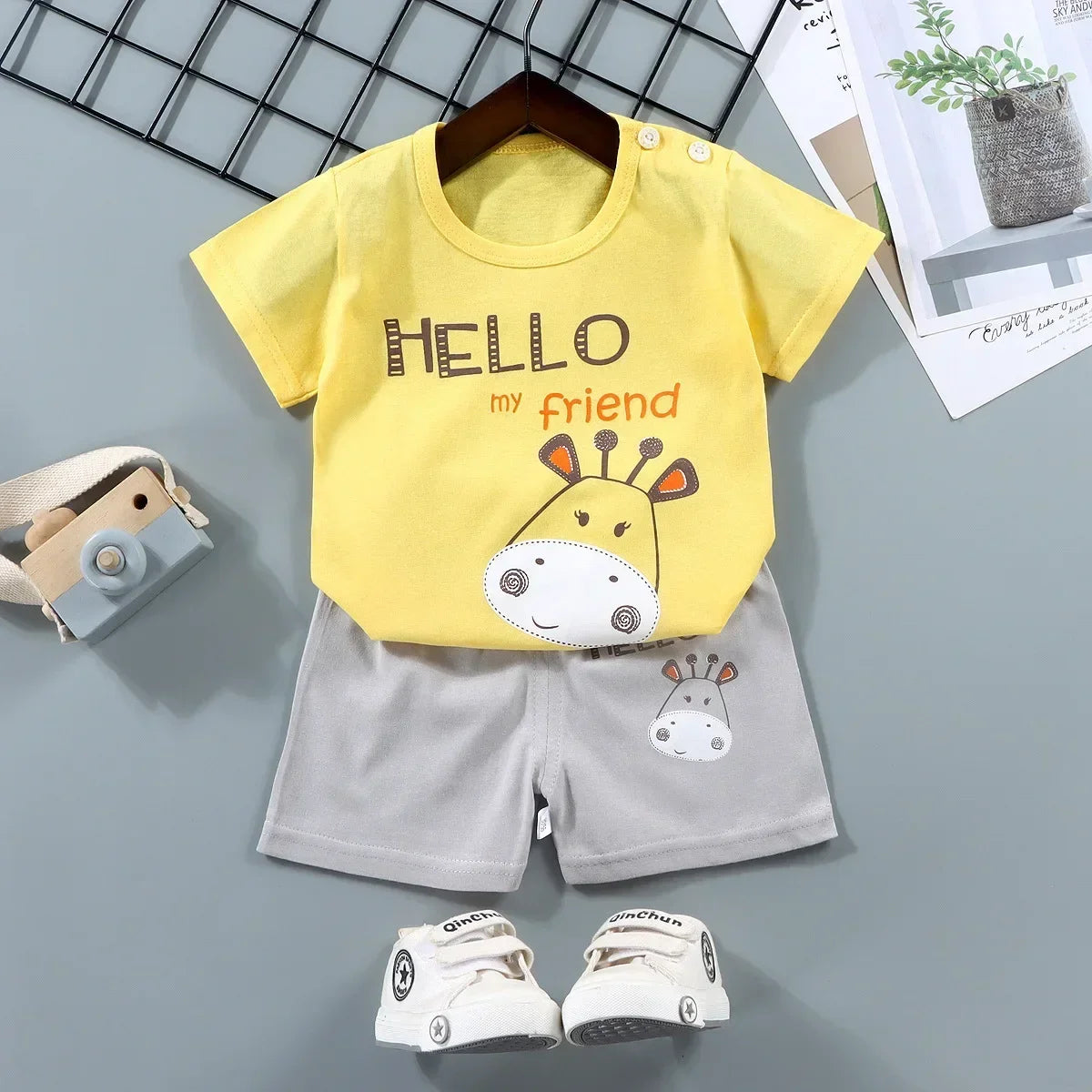 Children's yellow t-shirt with a giraffe design and gray shorts on a gray background.
