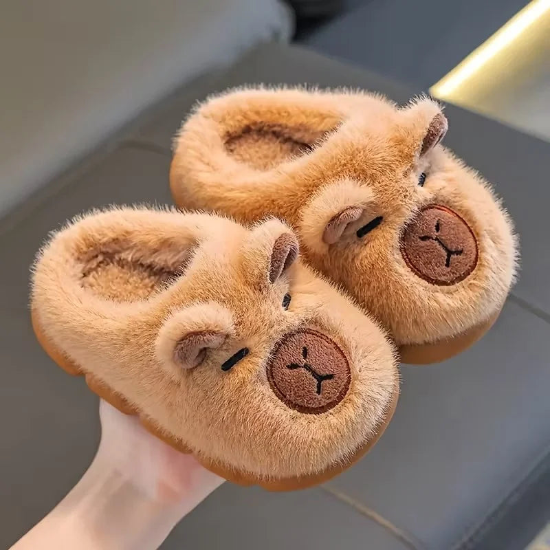 Pair of plush slippers with bear faces on a neutral background