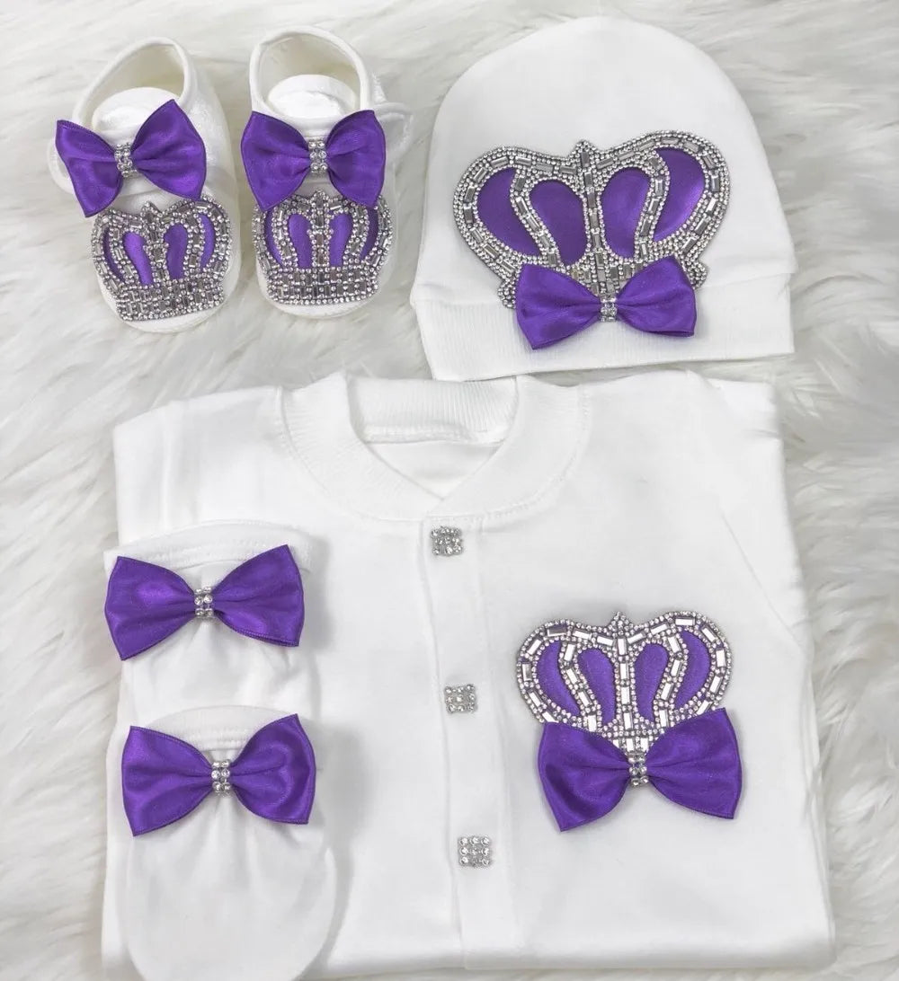 Baby outfit set with purple crowns and bows on a white background