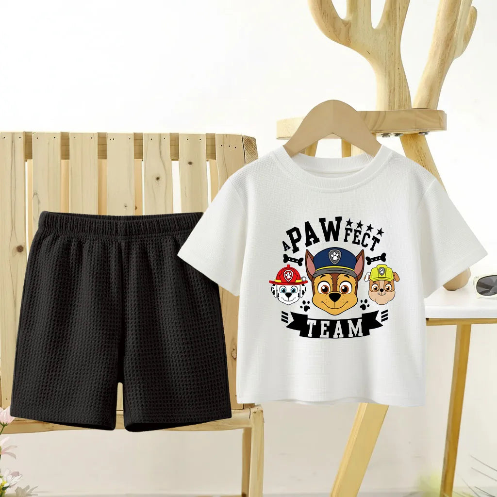 White t-shirt with 'PAWfect Team' design and black shorts on a wooden chair.