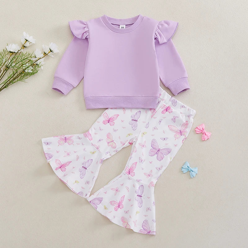 Purple sweatshirt and butterfly print pants with a hair clip on a beige background