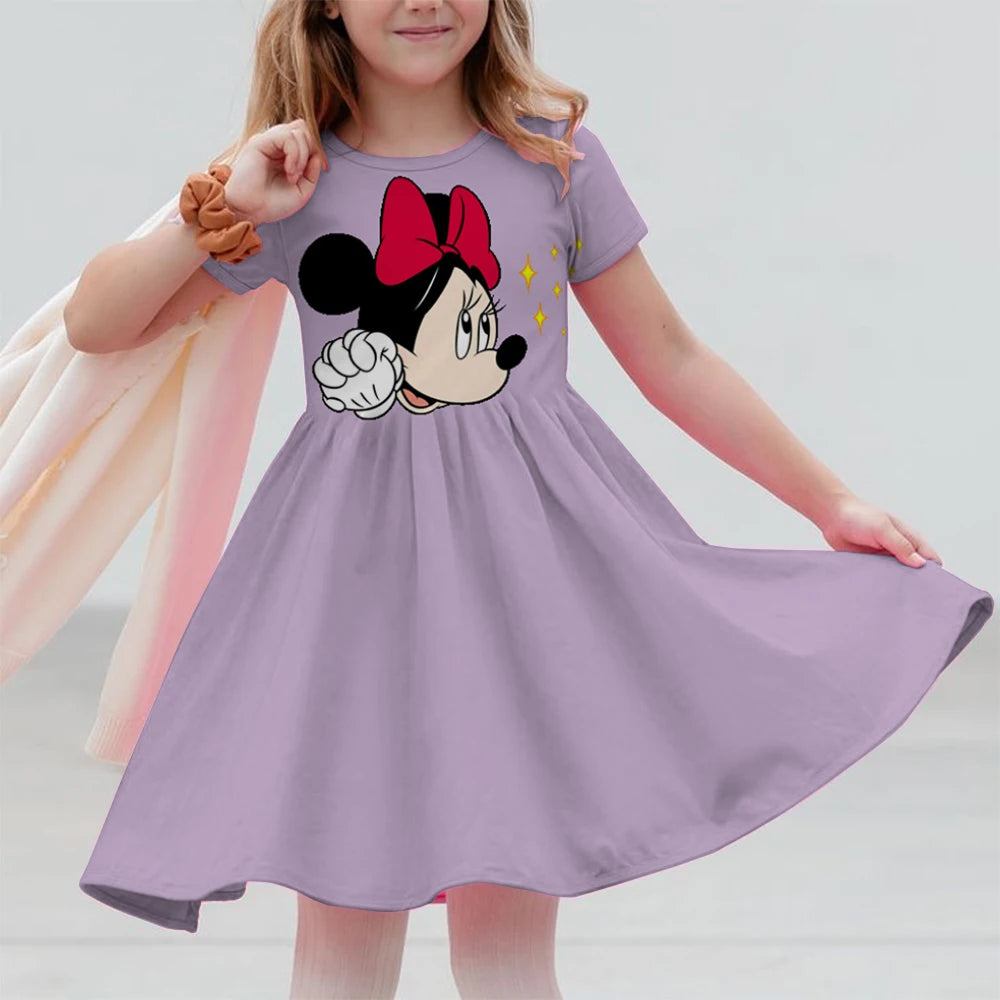 Child wearing a purple dress with a cartoon character design on a plain background