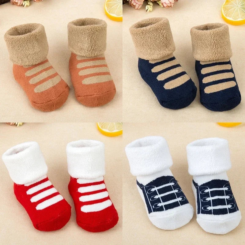 Set of baby socks in various colors with patterns on a beige background.