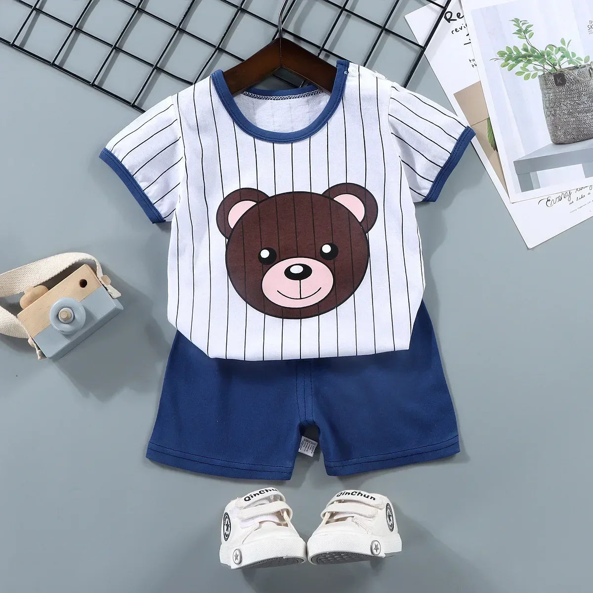 Children's outfit with bear design shirt and shorts on a gray background