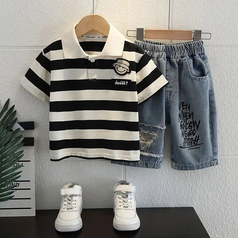 Children's outfit with striped polo shirt, denim shorts, and white sneakers on a white background.