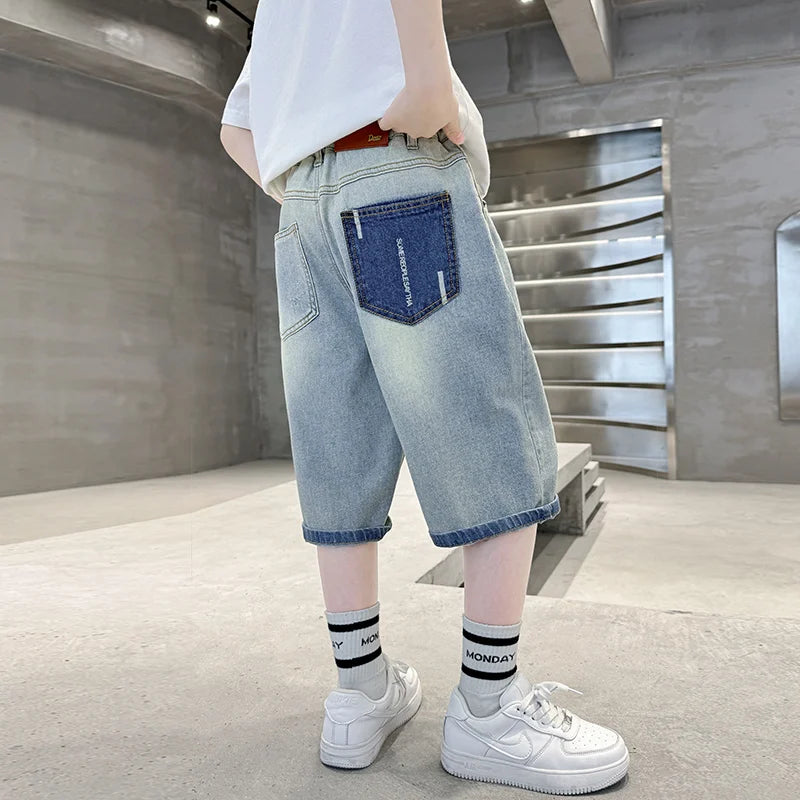 Person wearing light blue jeans and white sneakers in an indoor setting