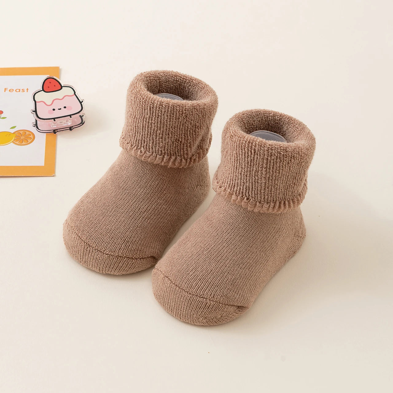 Pair of brown baby socks on a light background