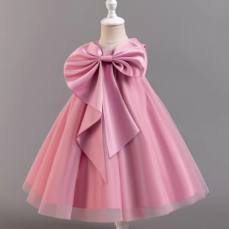 Pink dress with a large bow on a mannequin against a gray background