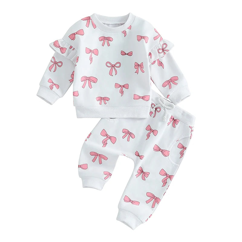 White children's pajama set with pink bow pattern on a white background