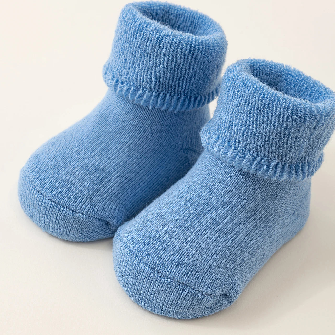 Pair of blue baby socks on a light background