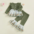 Green baby outfit with floral details on a light beige background
