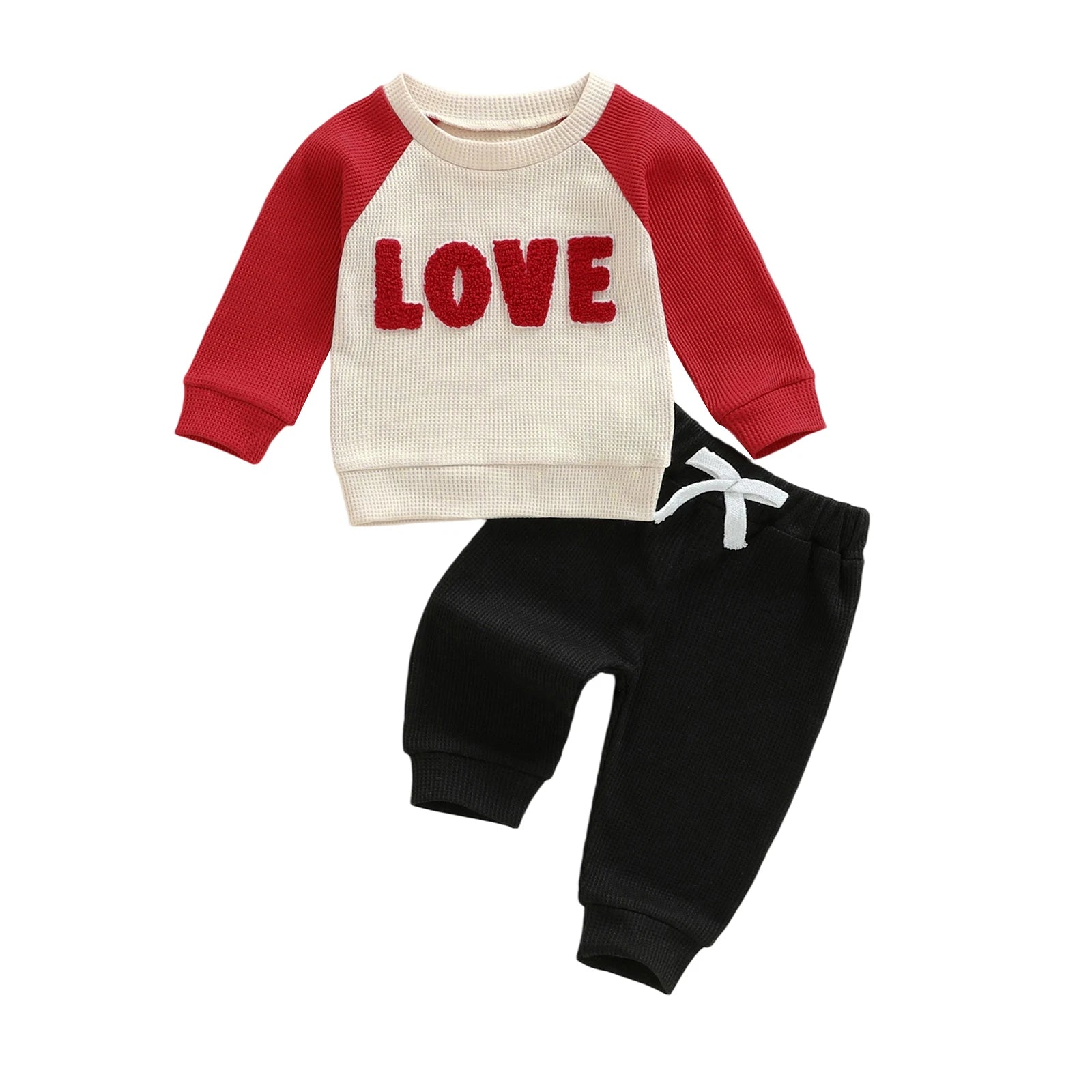 Children's outfit with red and beige long-sleeve top and black pants on a white background