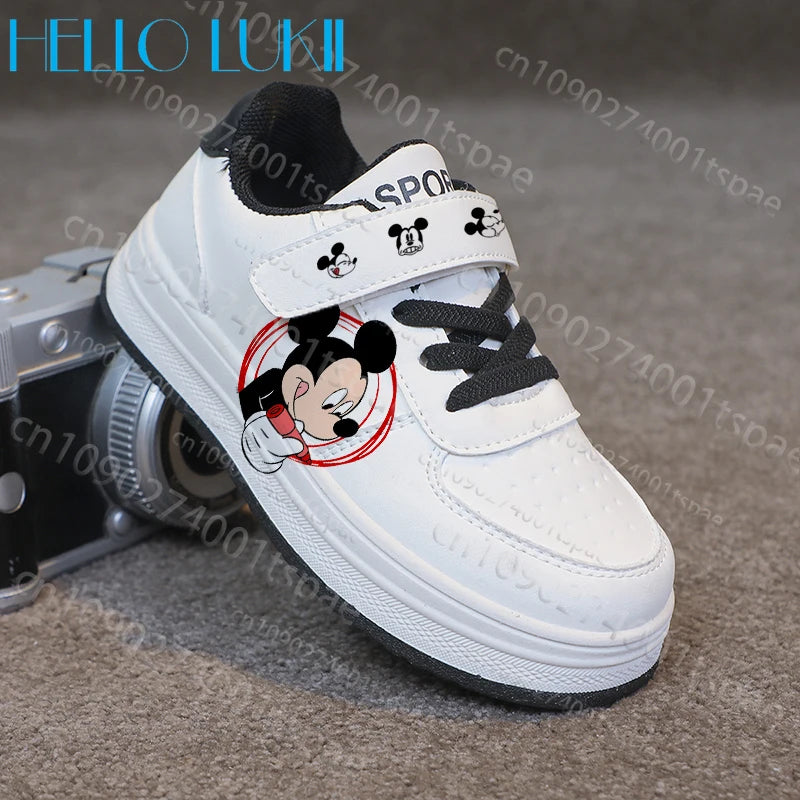 White sneaker with cartoon character design on a gray surface with a camera.