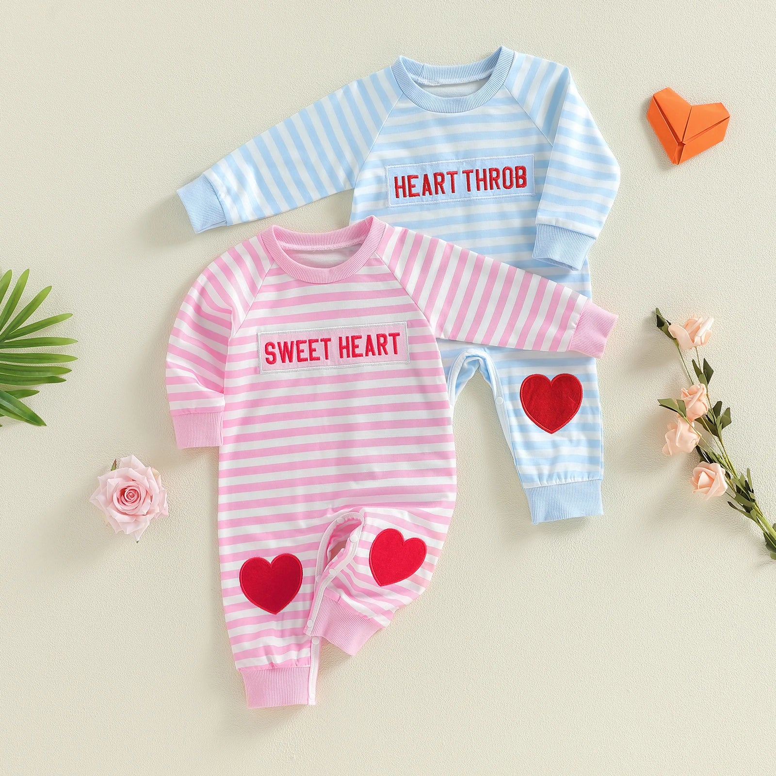 Two baby outfits with 'HEART THROB' and 'SWEET HEART' text, featuring hearts on a light background.