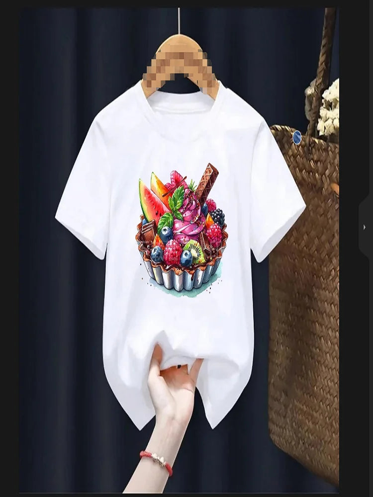 White t-shirt with a colorful fruit basket design on a hanger against a dark background.