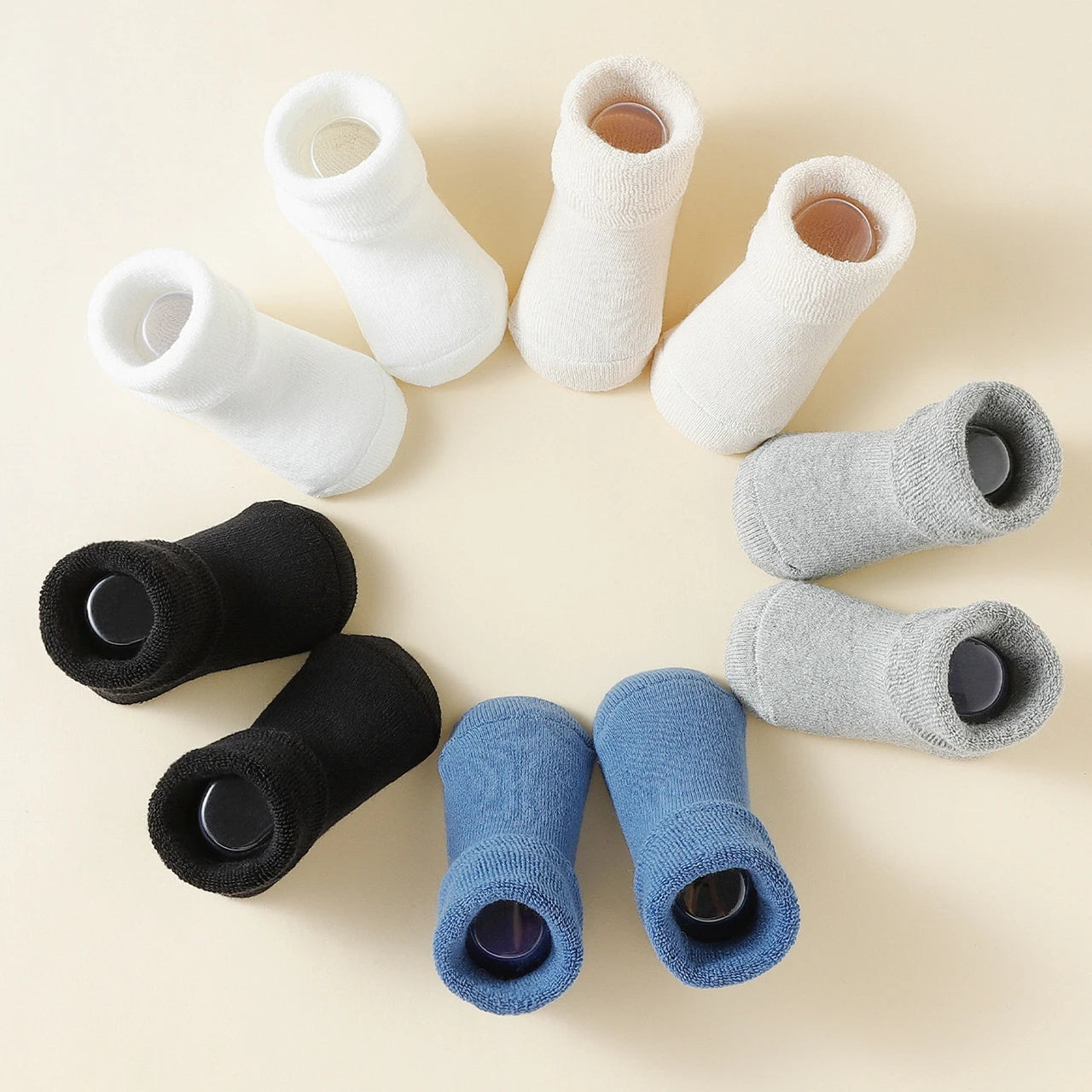 Set of white, black, and blue socks arranged in a circular pattern on a beige background.