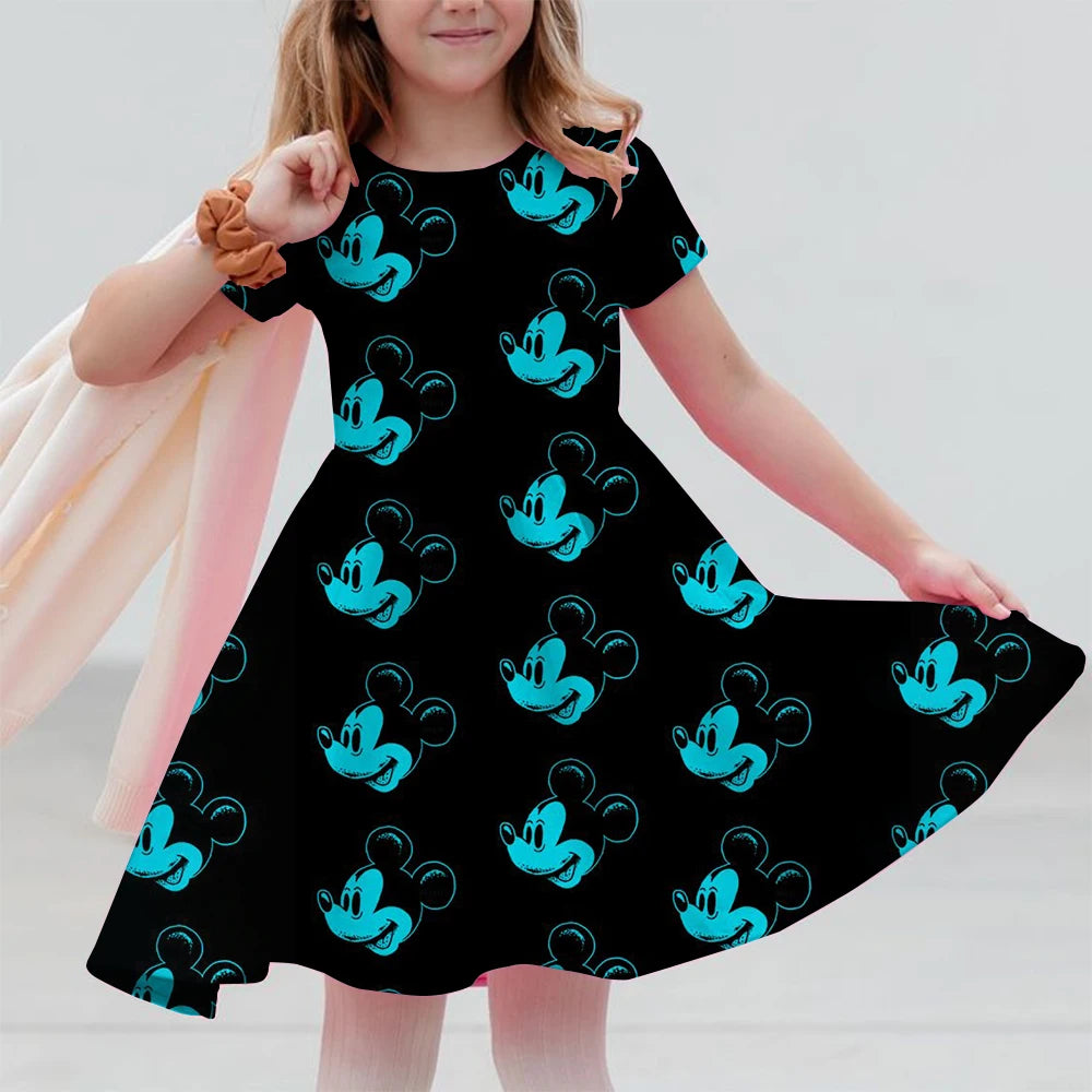 Child wearing a black dress with blue Mickey Mouse patterns on a plain background