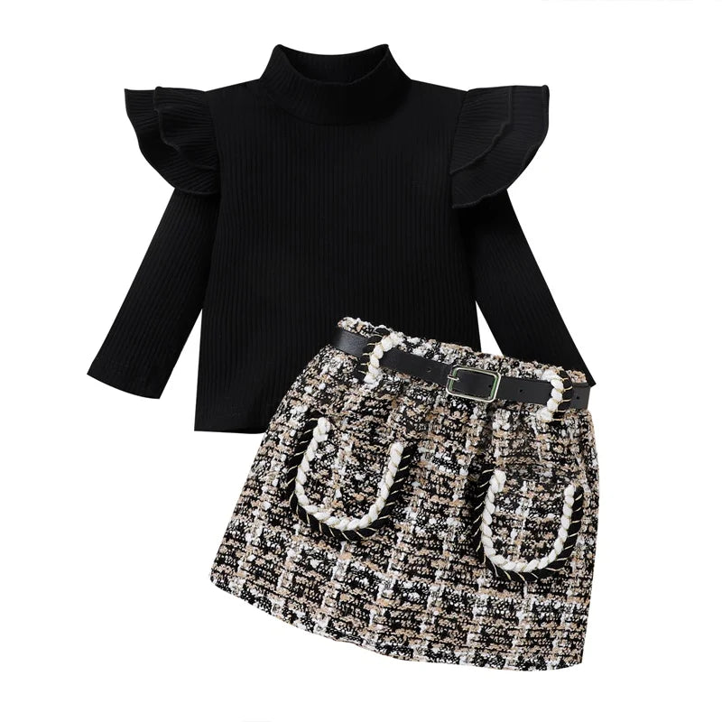 Black ruffled top and patterned skirt on a white background