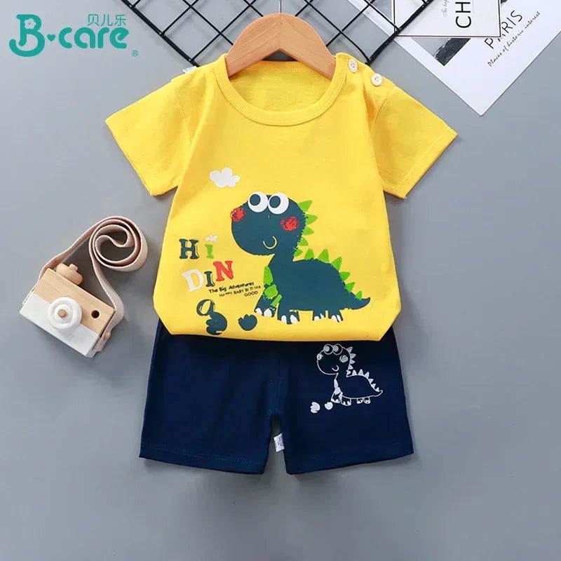 Children's yellow t-shirt with dinosaur design and navy shorts on a gray background, featuring the brand 'B-care'.
