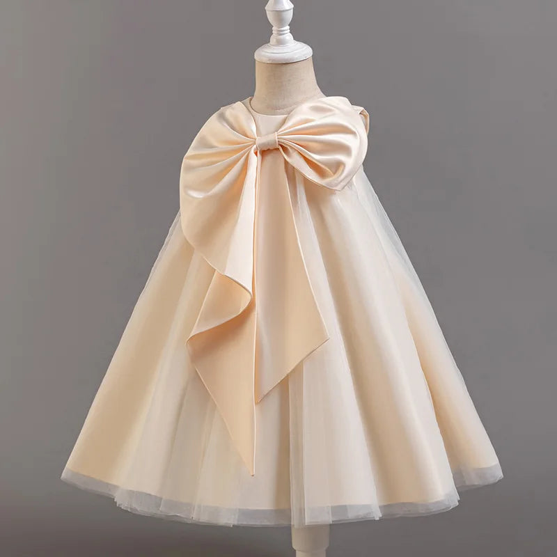 Beige dress with a large bow on a mannequin against a gray background