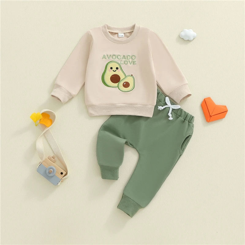 Children's outfit with pink sweatshirt and green pants on a beige background
