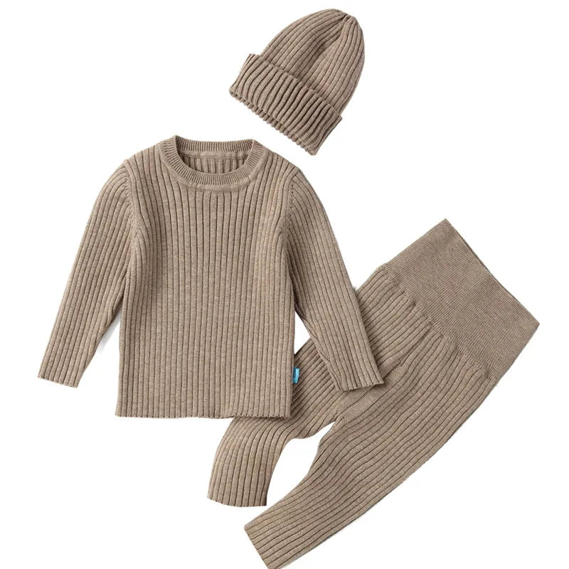 Beige knit sweater, pants, and beanie set on a white background