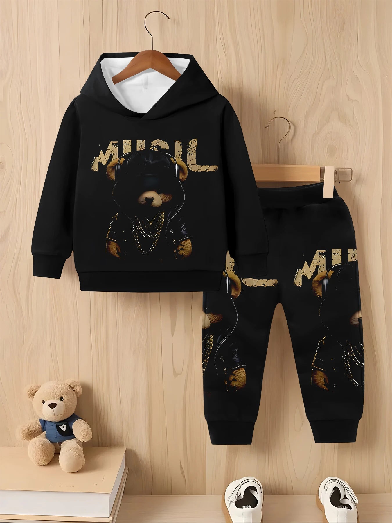 Children's black hoodie and pants set with bear design on a wooden background