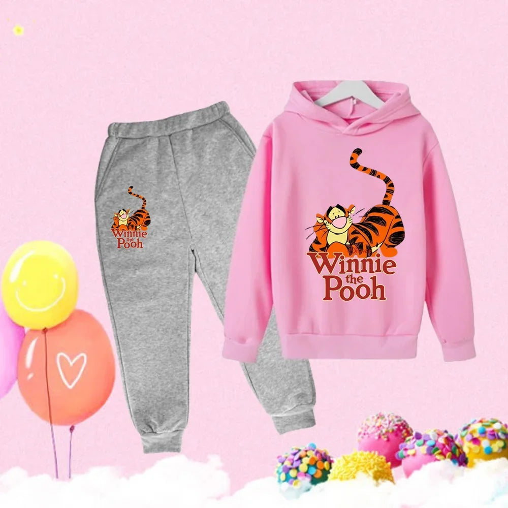 Pink hoodie and gray sweatpants with Tigger and Winnie the Pooh design on a pink background with balloons and candy.