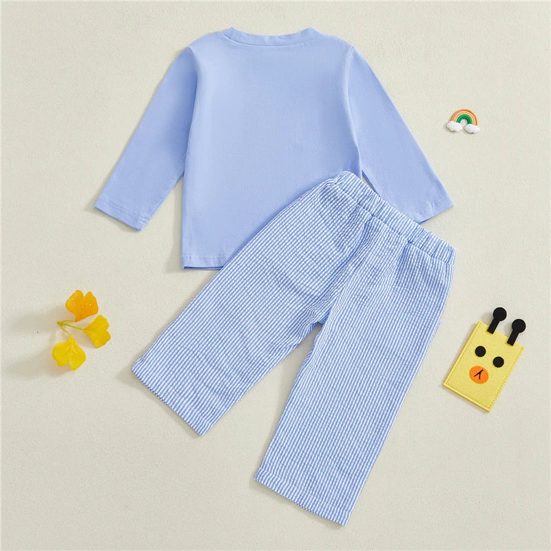 Children's blue outfit with long-sleeve top and striped pants on a light beige background.
