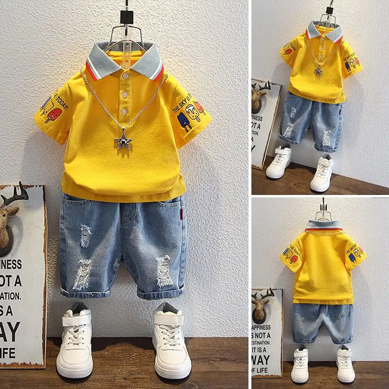 Children's outfit with yellow polo shirt and blue shorts on a wooden floor.