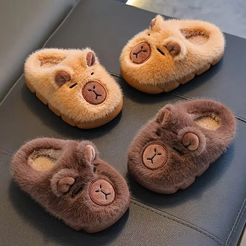 Four pairs of fluffy slippers with bear face designs on a dark surface.