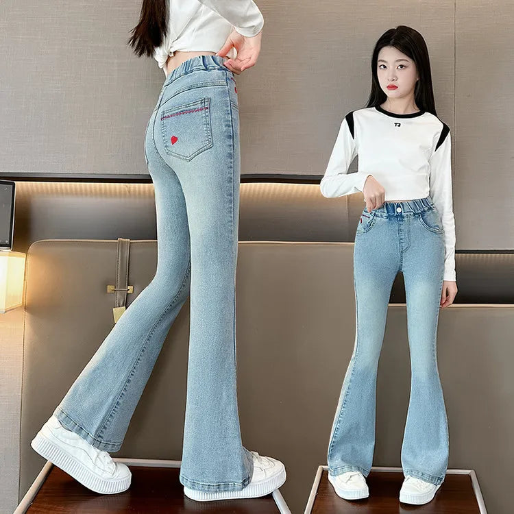 Light blue flared jeans worn by a person in a neutral indoor setting