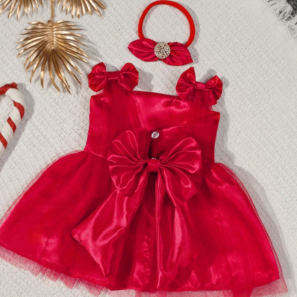 Red dress with large bow and matching headband on a textured surface