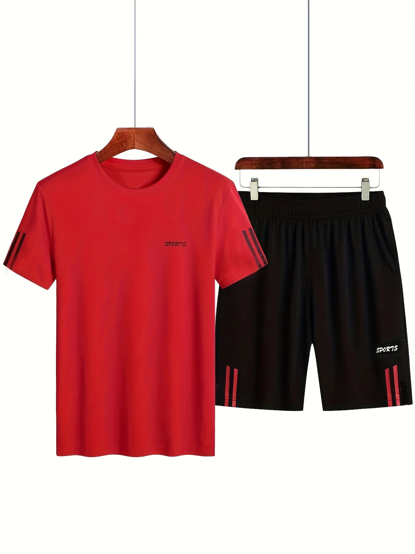Red t-shirt and black shorts set on hangers against a white background