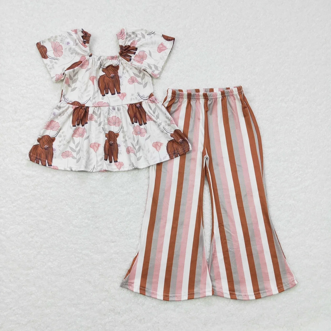Children's outfit with floral top and striped pants on a light gray background