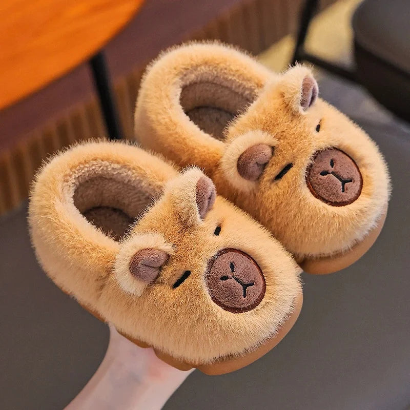 Pair of plush animal slippers with bear faces on a gray surface.