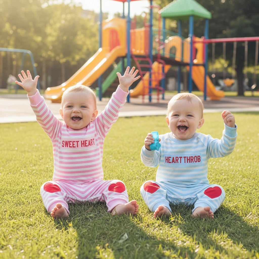 Two children in matching outfits with heart-themed text on a playground background