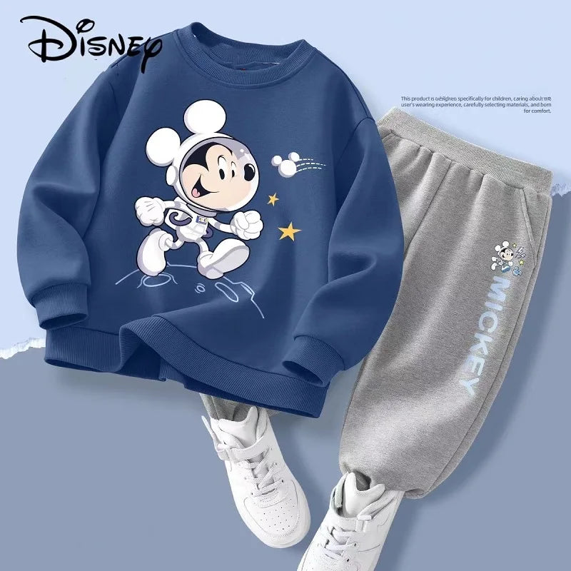 Children's outfit with blue sweatshirt and gray pants featuring a cartoon character, on a light blue background.