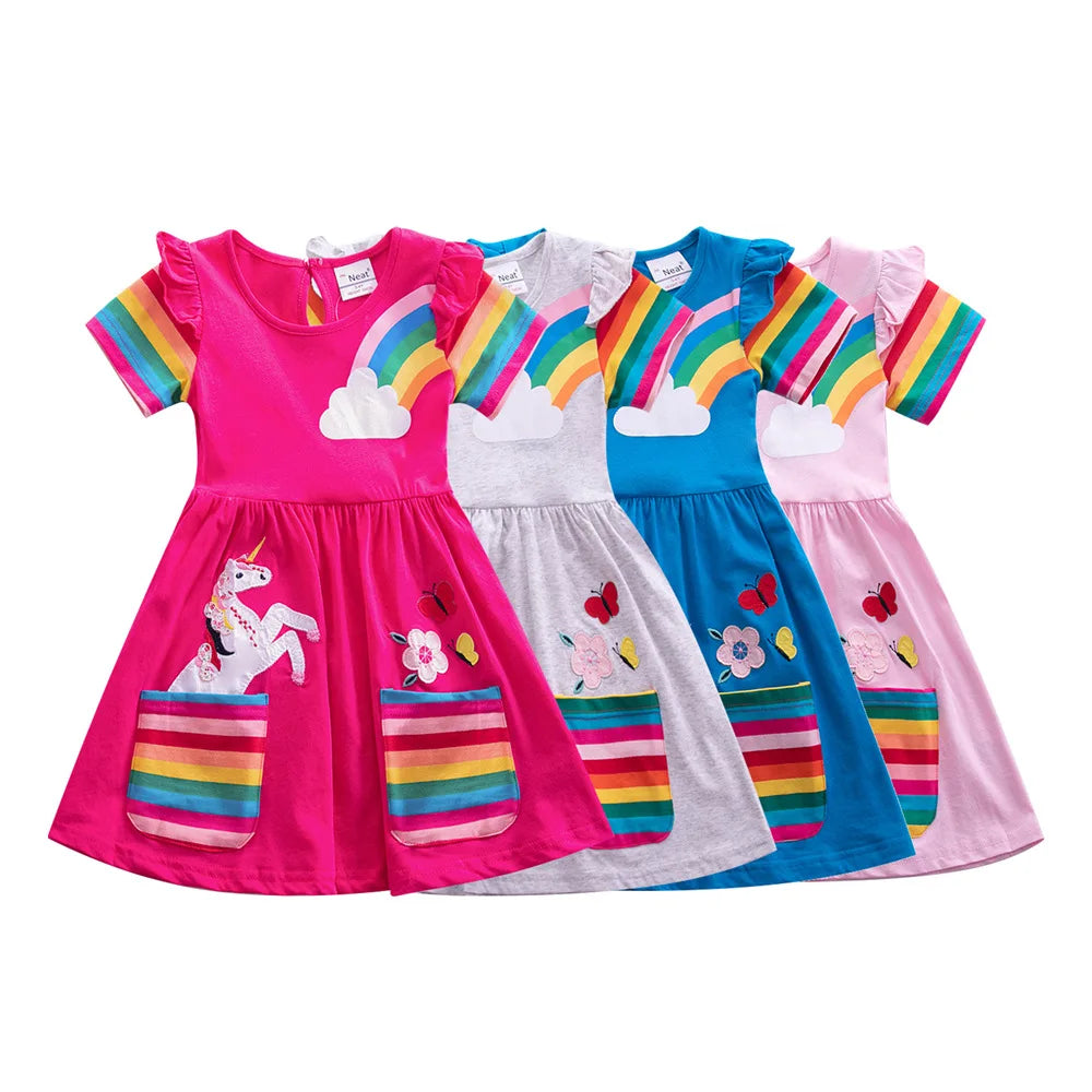 Four colorful children's dresses with rainbow designs on a white background