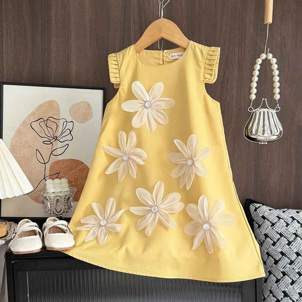 Yellow dress with floral patterns on a hanger against a wooden wall.