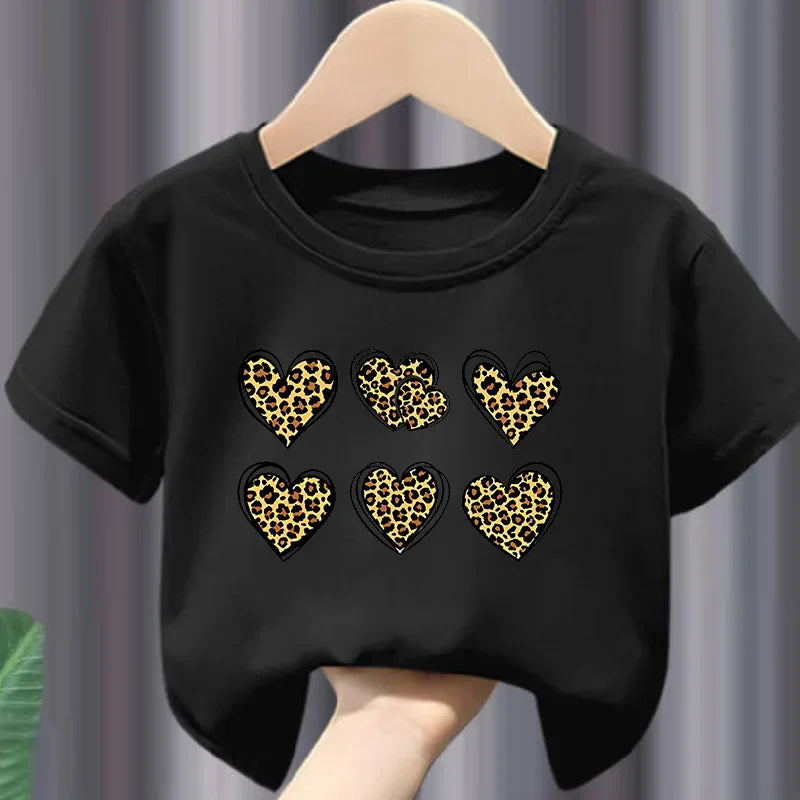 Black t-shirt with leopard print hearts on a hanger against a gray curtain background