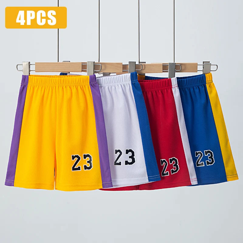 Four pairs of shorts in yellow, white, red, and blue with number 23 on a wooden rack against a light gray background.